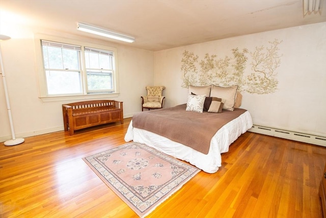 bedroom with hardwood / wood-style flooring and baseboard heating