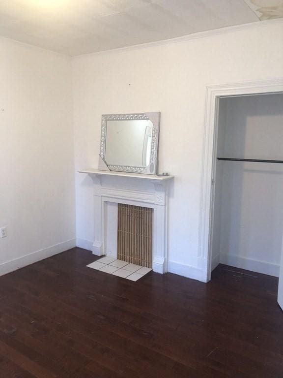 unfurnished living room with dark wood-type flooring