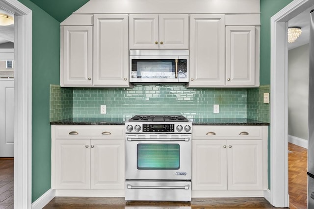 kitchen featuring white cabinetry, stainless steel appliances, backsplash, and baseboards