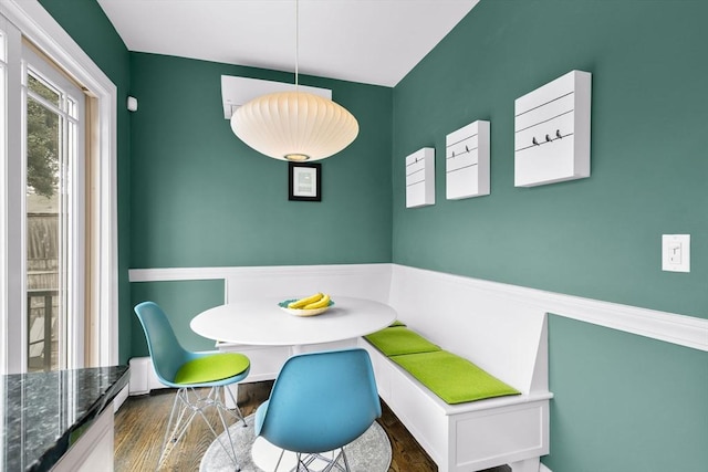 dining space with breakfast area and wood finished floors