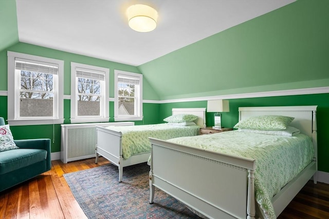 bedroom featuring baseboards, hardwood / wood-style flooring, and lofted ceiling