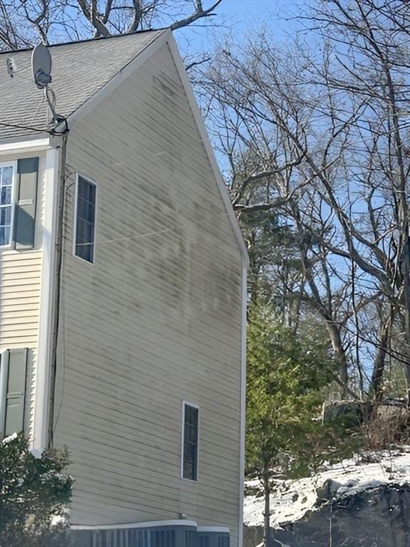 view of side of property with roof with shingles