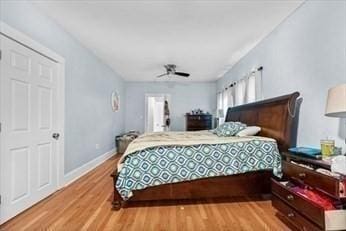 bedroom featuring a ceiling fan, baseboards, and wood finished floors