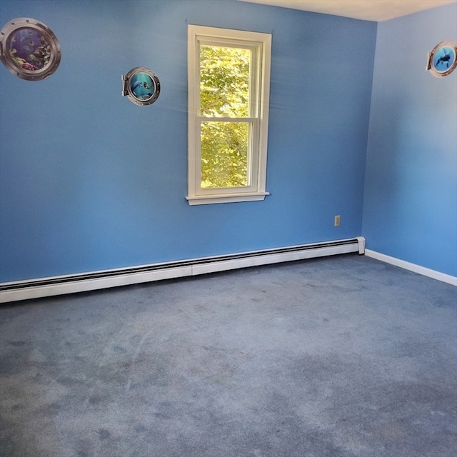 carpeted spare room with a baseboard heating unit