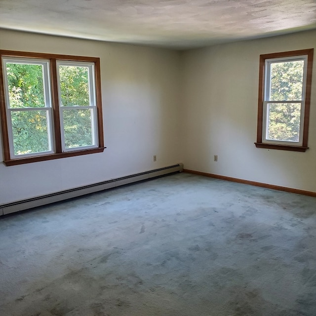 carpeted empty room featuring baseboard heating