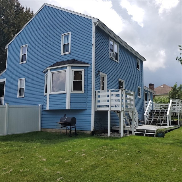 back of property featuring a yard and a wooden deck