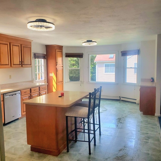 kitchen with dishwasher, a breakfast bar area, a baseboard radiator, and a kitchen island