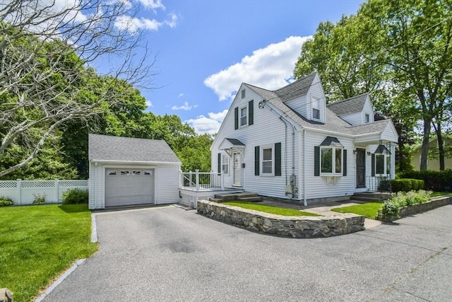 57 Strafford Rd, Westwood, MA 02090 - view of front of house with an outbuilding, asphalt driveway, a detached garage, and roof with shingles