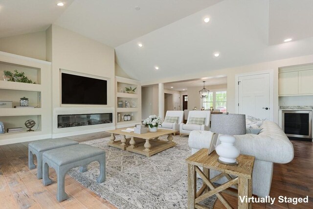 40 Blood Rd, Charlton, MA 01507 - living room featuring built in features, wood finished floors, recessed lighting, a glass covered fireplace, and high vaulted ceiling