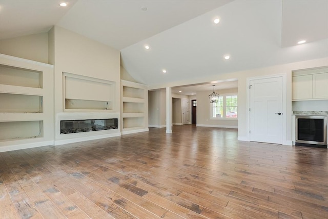 40 Blood Rd, Charlton, MA 01507 - unfurnished living room with built in features, vaulted ceiling, wood finished floors, a glass covered fireplace, and recessed lighting