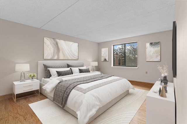 bedroom with hardwood / wood-style floors and a textured ceiling