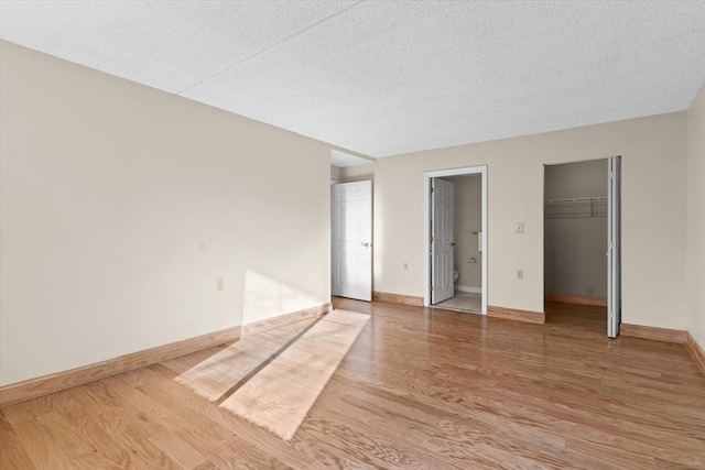 unfurnished bedroom featuring a closet, hardwood / wood-style floors, and a textured ceiling