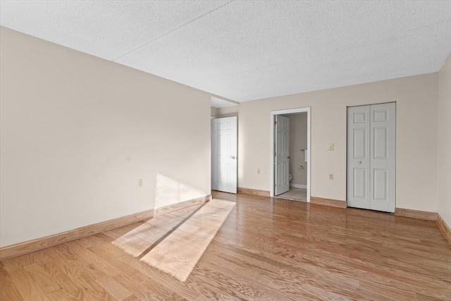 unfurnished room with wood-type flooring and a textured ceiling