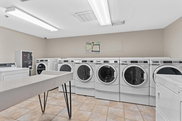 clothes washing area featuring separate washer and dryer and light tile patterned flooring