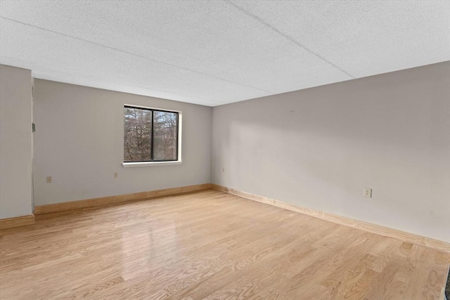 empty room with a textured ceiling and light wood-type flooring