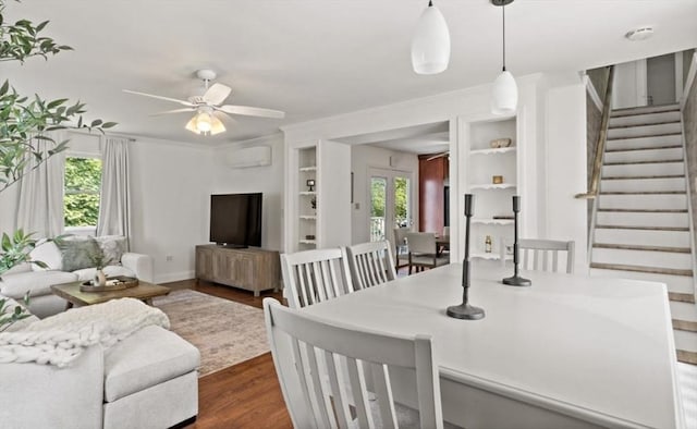 37 Saint Michaels Ave, Somerset, MA 02726 - dining space featuring an AC wall unit, built in features, stairs, dark wood finished floors, and a ceiling fan