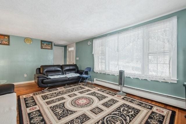 living room with a baseboard heating unit and hardwood / wood-style flooring