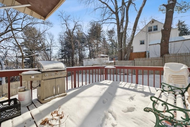 snow covered deck with a grill