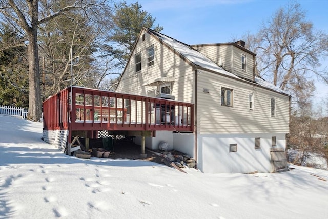 snow covered rear of property featuring a deck