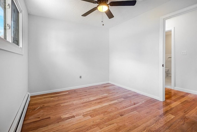 unfurnished room featuring light wood-type flooring, a ceiling fan, baseboards, and a baseboard heating unit