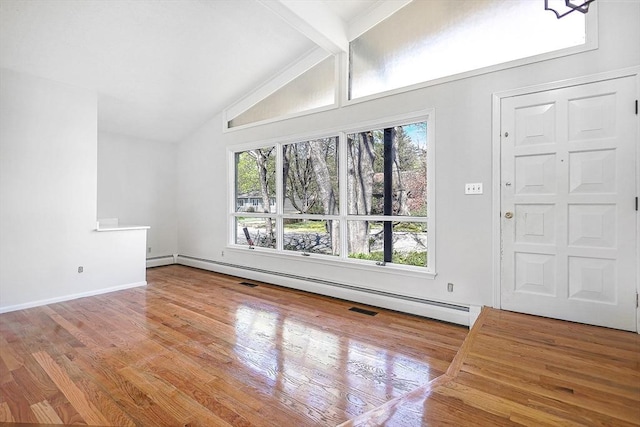 unfurnished living room with a healthy amount of sunlight, vaulted ceiling with beams, and wood finished floors