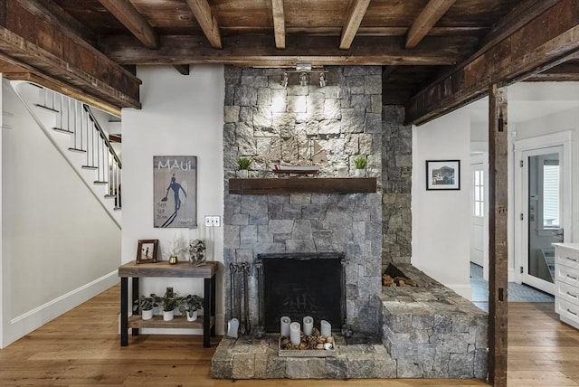 living room with baseboards, a fireplace, beamed ceiling, and hardwood / wood-style floors