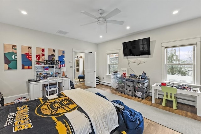 bedroom featuring ceiling fan, recessed lighting, wood finished floors, visible vents, and baseboard heating