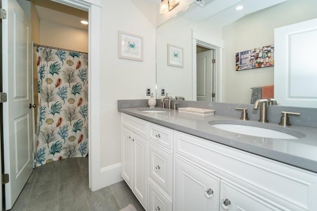 full bath with double vanity, recessed lighting, a sink, and tile patterned floors