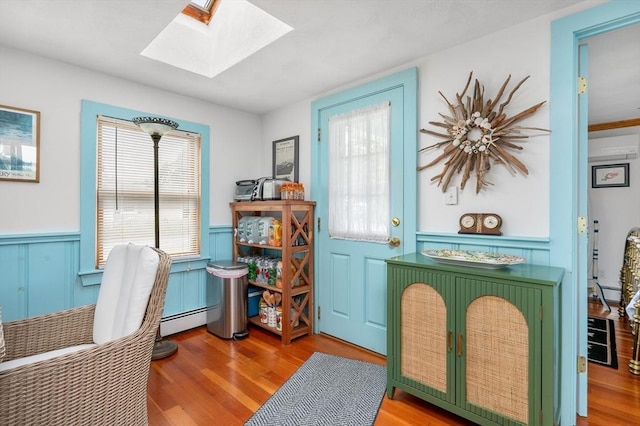 16 Gulls Cove Rd, Yarmouth, MA 02673 - office area with a skylight, wood finished floors, wainscoting, a decorative wall, and a baseboard radiator
