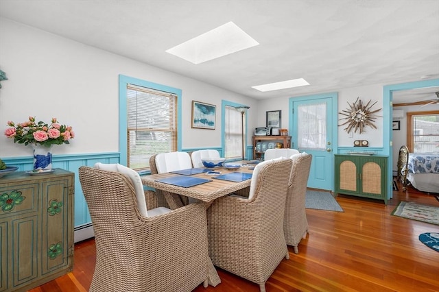16 Gulls Cove Rd, Yarmouth, MA 02673 - dining space featuring a skylight, a baseboard heating unit, wood finished floors, and wainscoting