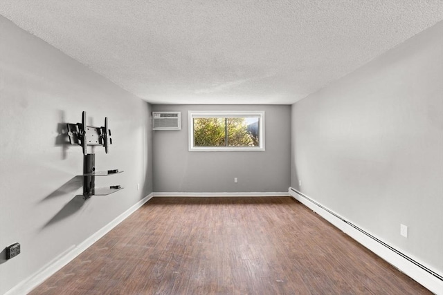 unfurnished room featuring wood-type flooring, an AC wall unit, a baseboard heating unit, and a textured ceiling