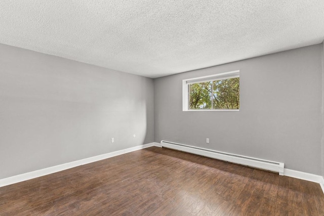 empty room with a baseboard radiator, dark hardwood / wood-style flooring, and a textured ceiling