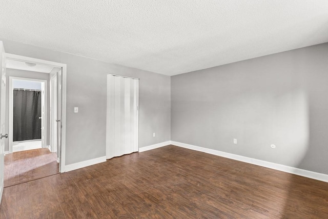 spare room with dark wood-type flooring and a textured ceiling