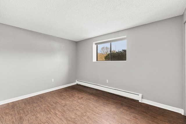 unfurnished room with dark hardwood / wood-style flooring, a textured ceiling, and a baseboard heating unit