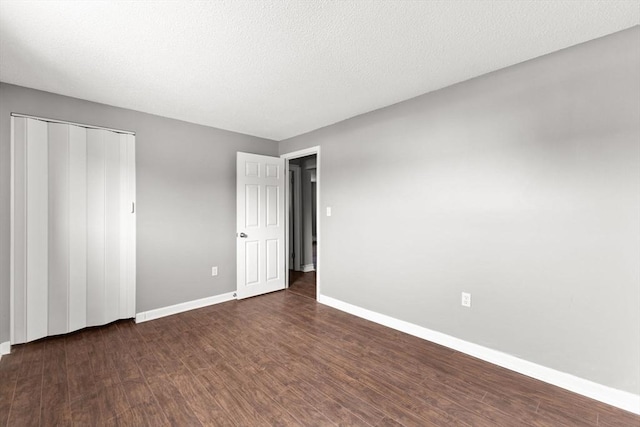 unfurnished bedroom featuring dark hardwood / wood-style floors, a closet, and a textured ceiling