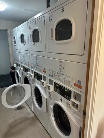 laundry area with stacked washer and clothes dryer, light tile patterned floors, and washing machine and clothes dryer