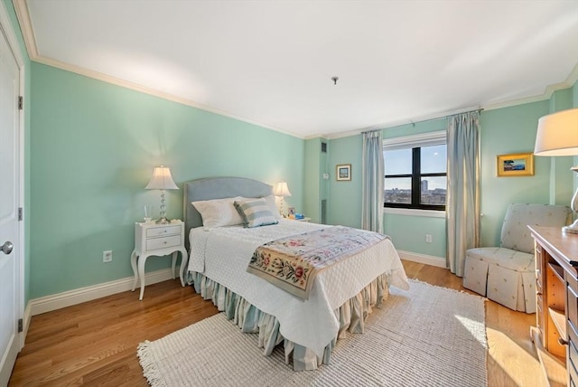 bedroom with crown molding and light wood-type flooring