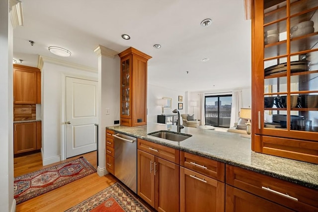 kitchen with crown molding, dishwasher, sink, light stone countertops, and light hardwood / wood-style floors