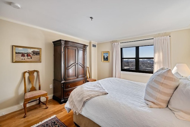 bedroom featuring light hardwood / wood-style floors and crown molding