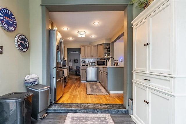 98 Moss St, New Bedford, MA 02744 - kitchen featuring stainless steel appliances, open shelves, light wood-style flooring, arched walkways, and recessed lighting