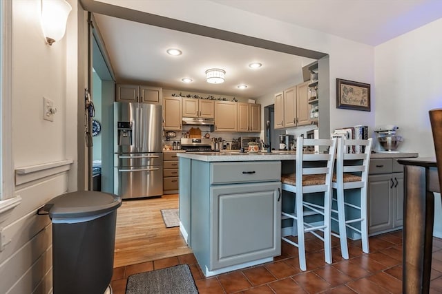 98 Moss St, New Bedford, MA 02744 - kitchen featuring appliances with stainless steel finishes, tile patterned flooring, under cabinet range hood, a peninsula, and light countertops