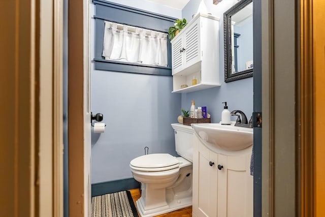 98 Moss St, New Bedford, MA 02744 - half bathroom featuring toilet, vanity, and wood finished floors