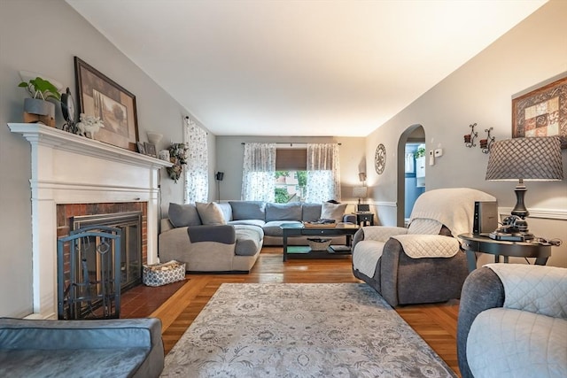 98 Moss St, New Bedford, MA 02744 - living area with arched walkways, a brick fireplace, and wood finished floors