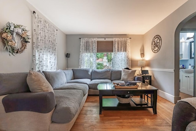 98 Moss St, New Bedford, MA 02744 - living room with arched walkways, wood-type flooring, and baseboards