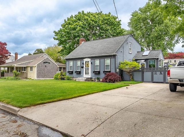 98 Moss St, New Bedford, MA 02744 - view of front of house with a chimney, driveway, a front lawn, and an outbuilding