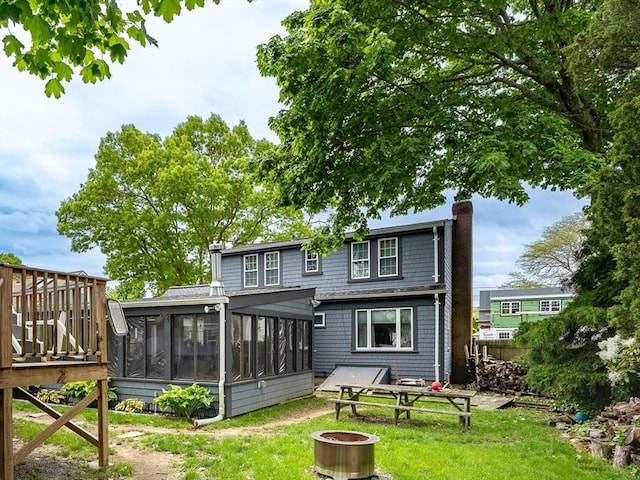 98 Moss St, New Bedford, MA 02744 - rear view of house featuring a sunroom, a yard, a deck, a fire pit, and a chimney