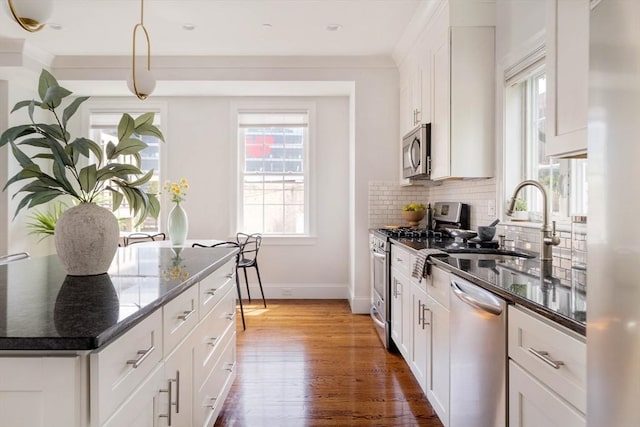 14 S Waverly St Unit 14, Boston, MA 02135 - kitchen with appliances with stainless steel finishes, baseboards, wood finished floors, white cabinets, and decorative backsplash