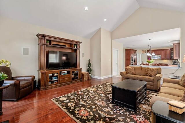 living area with high vaulted ceiling, wood finished floors, and recessed lighting