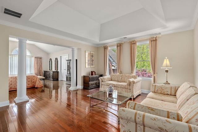 living room featuring ornate columns, a tray ceiling, and hardwood / wood-style flooring