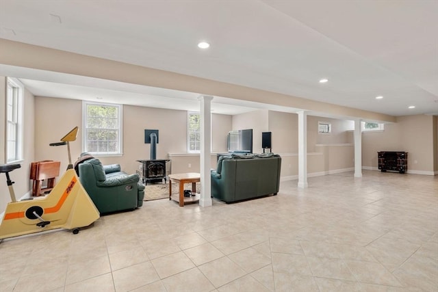 living area with a wood stove, recessed lighting, light tile patterned floors, and baseboards